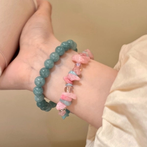 Close-up of blue camellia beaded bracelets with natural stones on a female wrist
