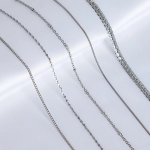 Polished silver necklaces in five different chain styles for women displayed on silk
