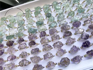 Detailed rows of handmade wire-wrapped natural crystal rings in purple and green hues