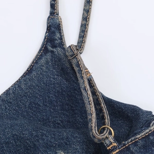 Detail of blue denim dress adjustable shoulder straps with high-quality metal hardware