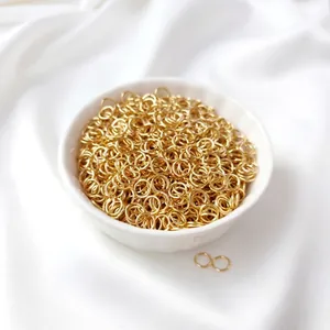 Bulk 18K gold-plated open jump rings in a white ceramic bowl for DIY jewelry making