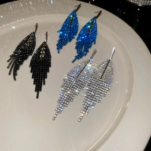 Detail of three pairs of rhinestone tassel earrings in black, blue and silver finishes