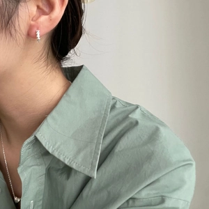 Minimalist S925 sterling silver leaf hoop earrings worn by a model in a side view