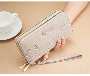 Detail of beige quilted leather long wallet with floral print and double zipper