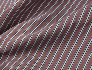 Macro view of brown and blue striped poplin fabric texture showing soft draping