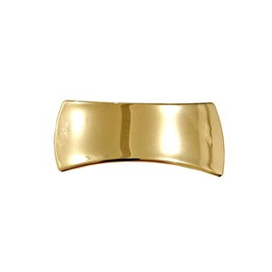 Close-up of polished golden bow metal hair clip with glossy finish on white background
