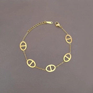 Detail view of a gold titanium steel bracelet featuring classic pig nose link design motifs
