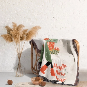 Detail of woven Christmas blanket featuring festive tassels and Happy New Year text