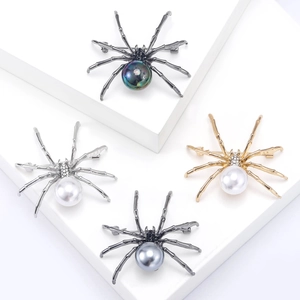 Creative spider brooches with colorful rhinestones and pearls on a white display