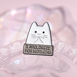 Cute white cat enamel pin with I Apologize For Nothing slogan on pink background