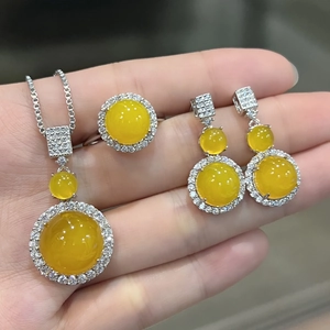 Detailed close-up of translucent yellow gemstone jewelry set held in hand