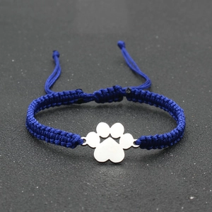 Detail of blue hand-woven lucky bracelet with adjustable knot and silver paw pendant