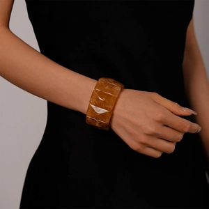 Macro detail of amber resin geometric bangle with marble texture on female model wrist