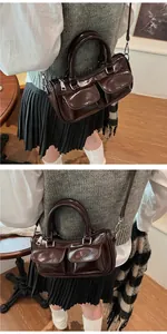 Detailed view of deep brown glossy saddle bag with double pockets and vintage hardware