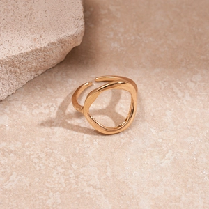 Close-up of golden irregular geometric open ring with polished organic lava texture