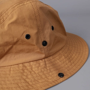 Detail view of khaki quick-dry sun hat with breathable vents and metal snap buttons