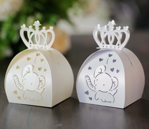 Detail of laser-cut elephant and heart patterns on pink and white paper gift boxes