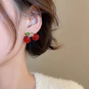 Elegant cherry stud earrings with red resin fruits and green zircon leaves on gold stems