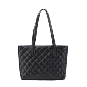 Close-up of black quilted stitching and smooth leather texture on women's tote bag