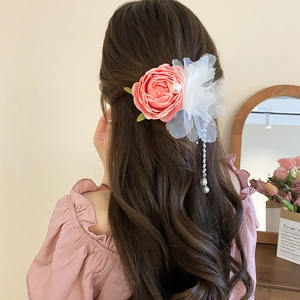 Lace rose hair clip with faux pearls and long tassels shown on a model's hair