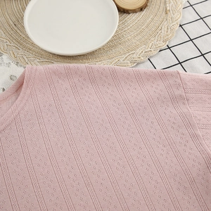 Close-up of pink knitted top with hollow mesh texture on home decor background