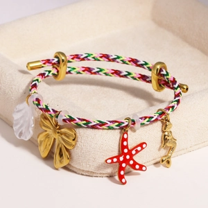 Detailed shot of braided bracelet with seashell, bow, starfish and mermaid pendants