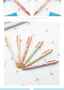 Detail of floral retractable ballpoint pens with elegant rose gold metal clips and tips