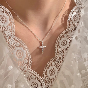 Collana a croce in argento con zirconi colorati su catena sottile indossata da modella