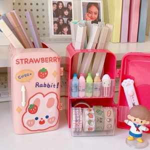 Detailed view of pink refrigerator-shaped pen holder with cute stickers and stationery items