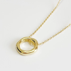 Minimalist 925 sterling silver necklace with irregular golden pendant on ivory surface