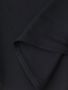 Close-up of black V-neck dress fabric texture and professional hem stitching detail