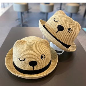Detail of straw sun hat with cute cat ears embroidery and black ribbon for toddlers