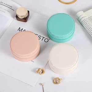 Portable round travel jewelry case in pink, cyan and cream PU leather with gold zipper
