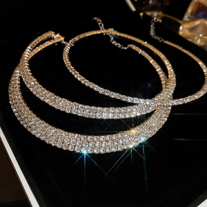 Detail of layered silver necklaces with sparkling diamonds on black velvet background