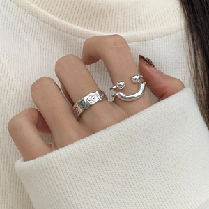 Detailansicht eines trendigen silbernen Ring-Sets für Damen mit Smiley- und Herzmotiven