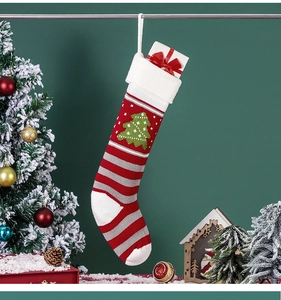 Knitted Christmas stocking with green tree pattern and a red bow gift box inside