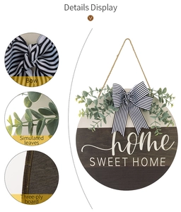 Detail view of wooden Home Sweet Home sign with eucalyptus leaves and striped bow