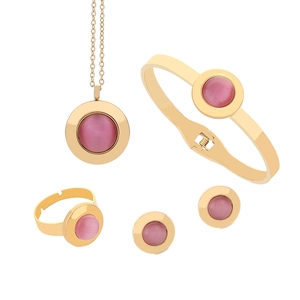 Detailed flat lay of gold titanium jewelry set with pink cat eye stones on white backdrop