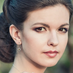 Elegant water drop earrings with olive green zirconia and matching thin gold necklace on model