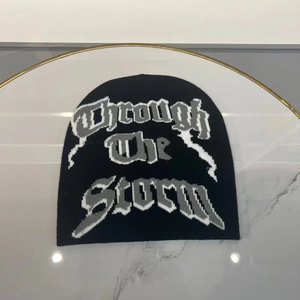 Detail of the Through the Storm gothic lettering on black knitted beanie hat
