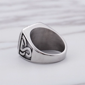 Macro view of men's wide stainless steel ring with S-shaped relief and brushed texture