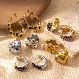 Collection of gold and silver heart and C-shaped earrings with micro-inlaid stones