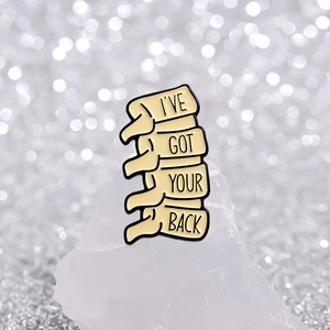 Creative skeletal spine enamel brooch with I've Got Your Back quote on white crystal
