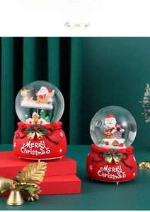 Macro view of Christmas crystal ball snow globe with Santa Claus and festive base