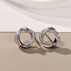 Macro shot of silver intertwined hoop earrings with sparkling cubic zirconia pavé setting