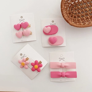Pink heart and bow hair clip set with matte finish on white display card