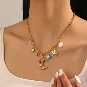 Close-up of gold stainless steel necklace with sun, moon, and star charms worn by model