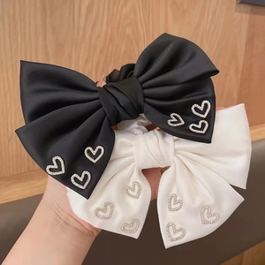 Elegant black and white satin bow scrunchies featuring sparkling rhinestone hearts