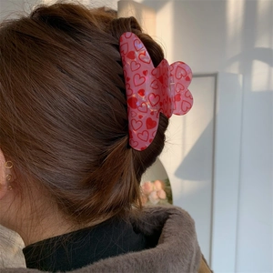 Red heart pattern hair claw clip shown on model hair for Valentines Day style