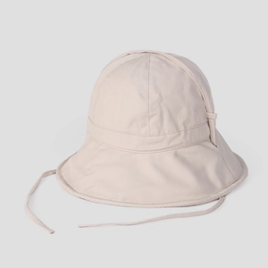 Close-up of beige sun bucket hat with adjustable chin strap and premium cotton fabric